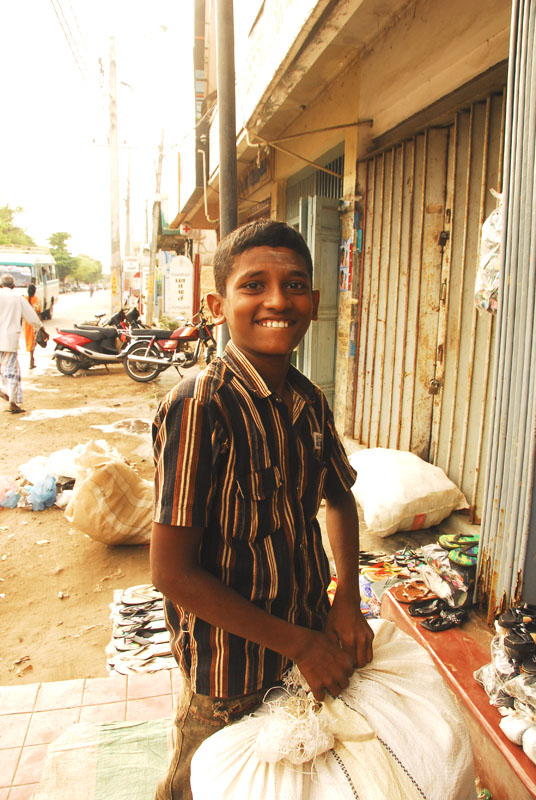 Young boy helping out in a shop is highly amused that I want to take his photo. Photograph©Chulie de Silva