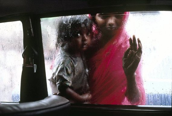  India. Bombay. 1993. A mother and child ask for alms through a taxi window during the monsoon. © Steve McCurry/Magnum Photos
