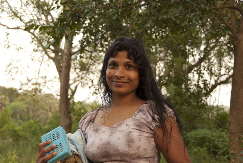 A woman returns after an evening bath in a stream at Mahavillachiya, Sri La...